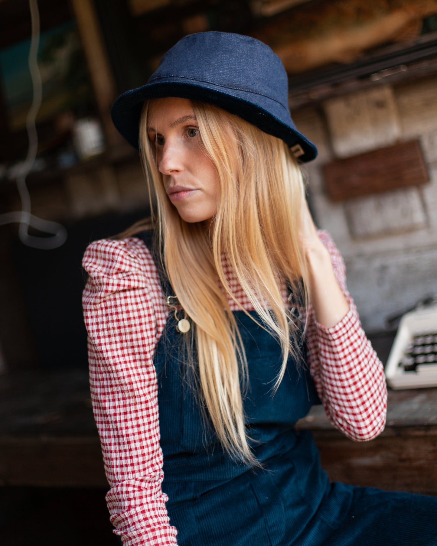 Mannequin portant le bob denim bleu Recyclette, accompagné de la salopette en velours bleu.
