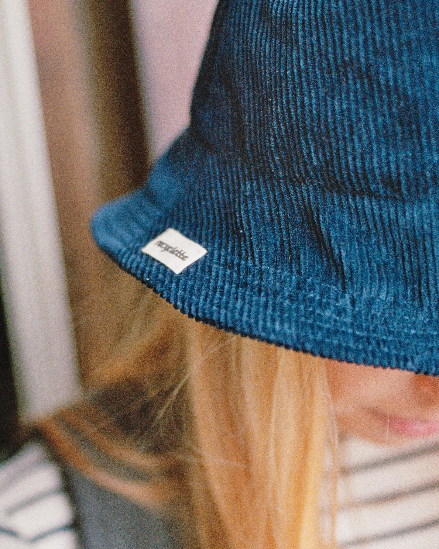 Photo d'un bob en velours bleu avec l'étiquette Recyclette.