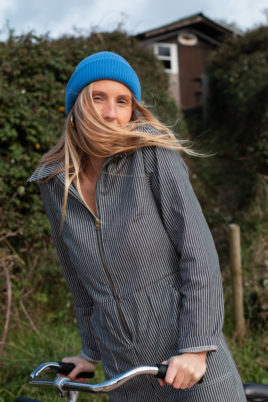 Zoom sur la combinaison rayée bleu et blanche, avec le bonnet Recyclette bleu.