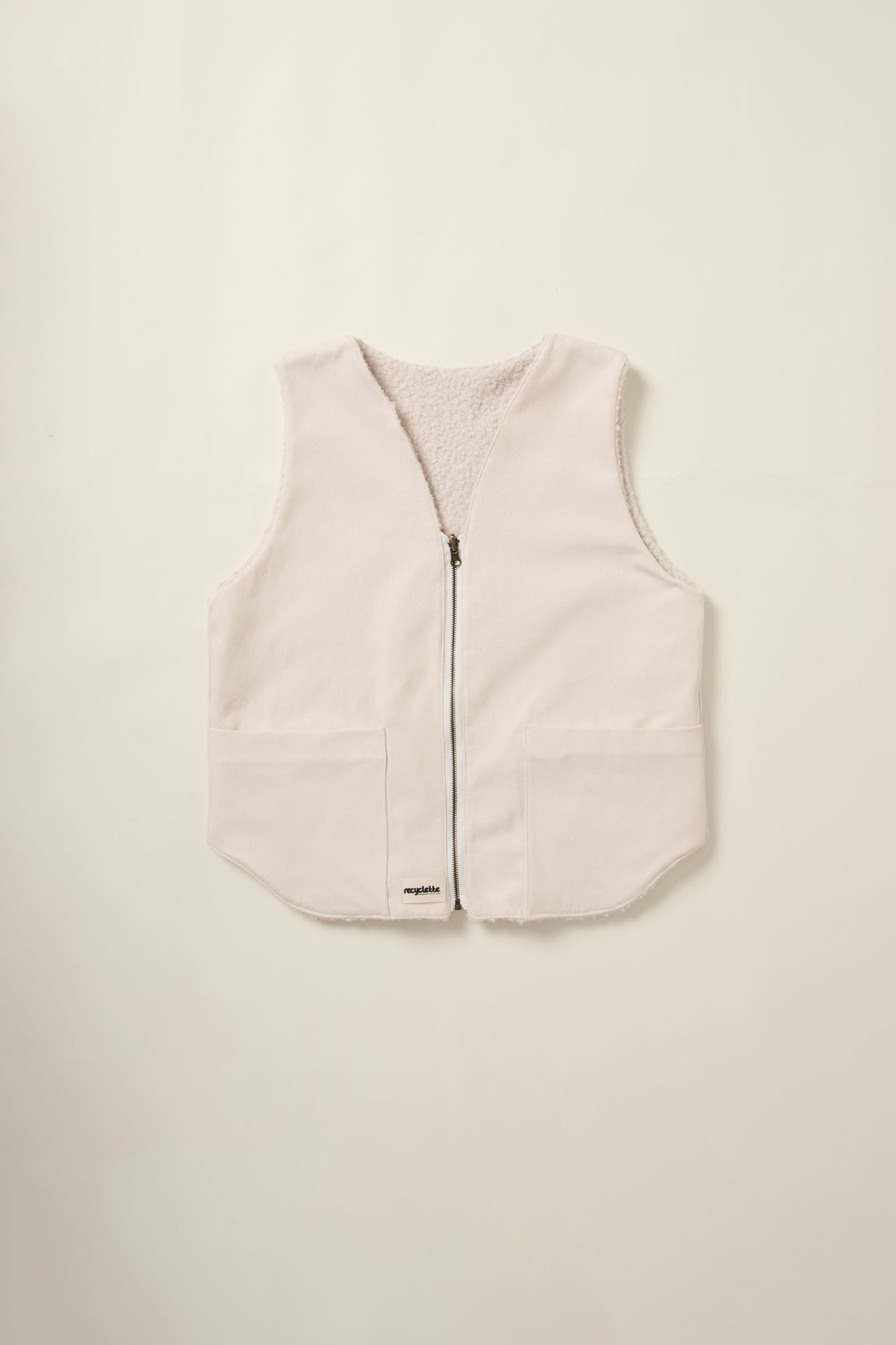 Gilet réversible, sans manche, coté denim crème, en aplat.