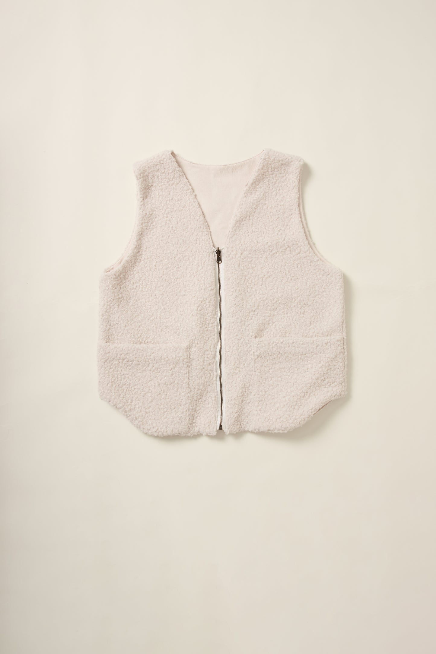 Gilet réversible sans manche du coté moumoute crème en aplat.