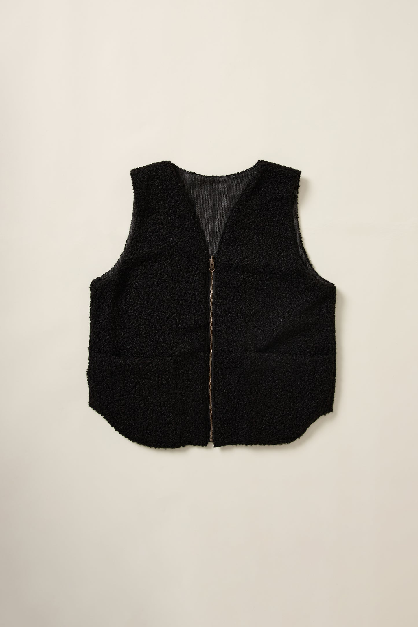 Gilet réversible, sans manche, coté moumoute noir, en aplat.