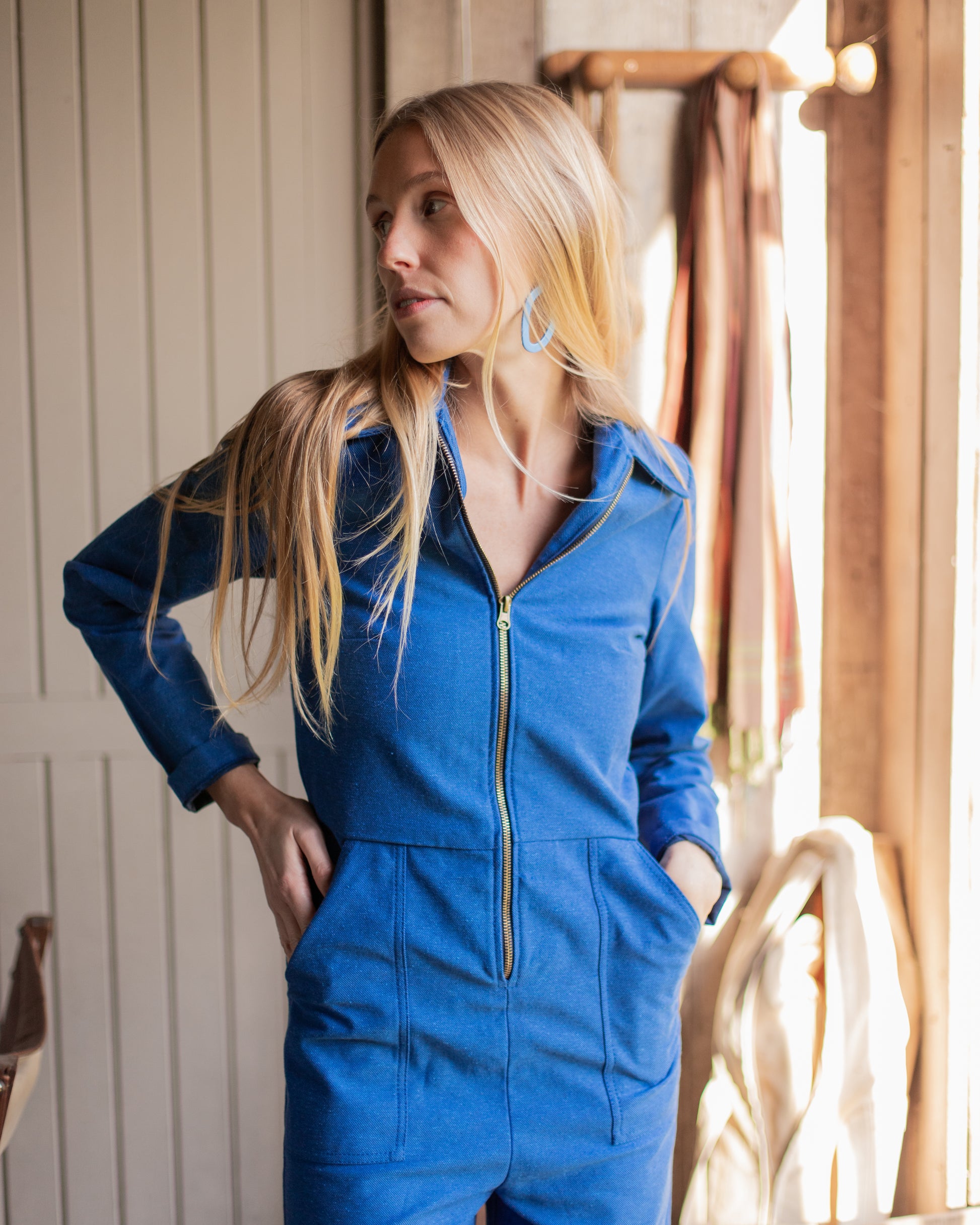 Femme portant une combinaison de travail bleue en tissu upcyclé, style vintage et coupe moderne.