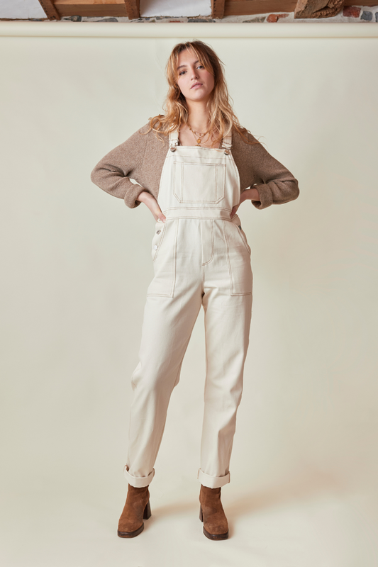 La salopette crème en modèle fernando, avec un pull marron clair et des bottines à talons.