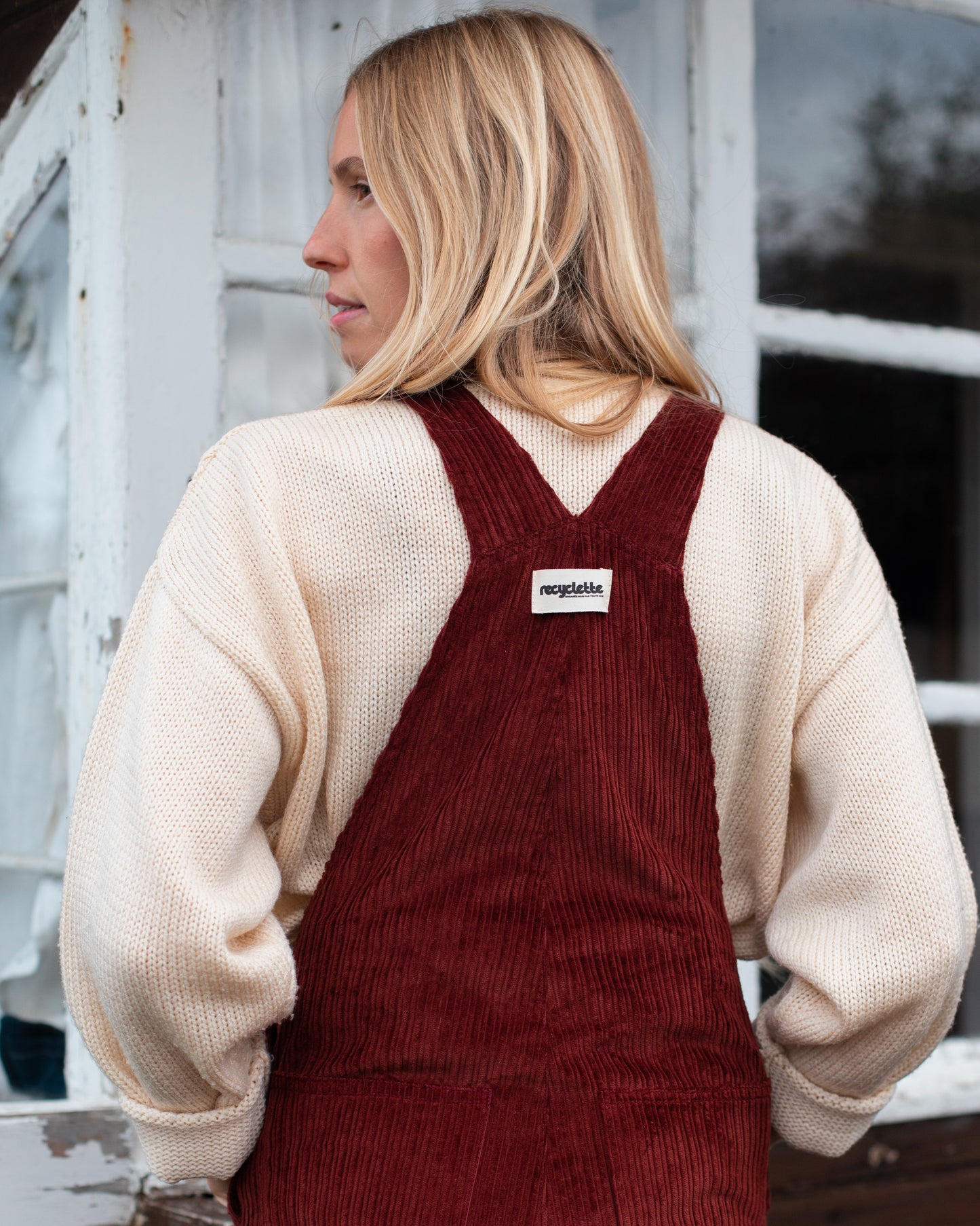 Salopette en velours bordeau modèle Dancing Queen portée par une mannequin, associée à un pull beige.