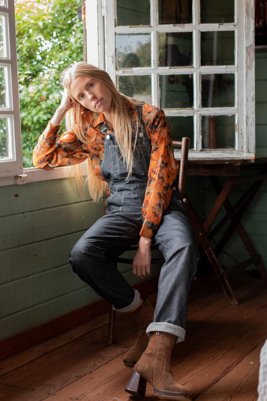 La salopette en denim gris, en modèle Fernando, avec uen blouse fleuries.