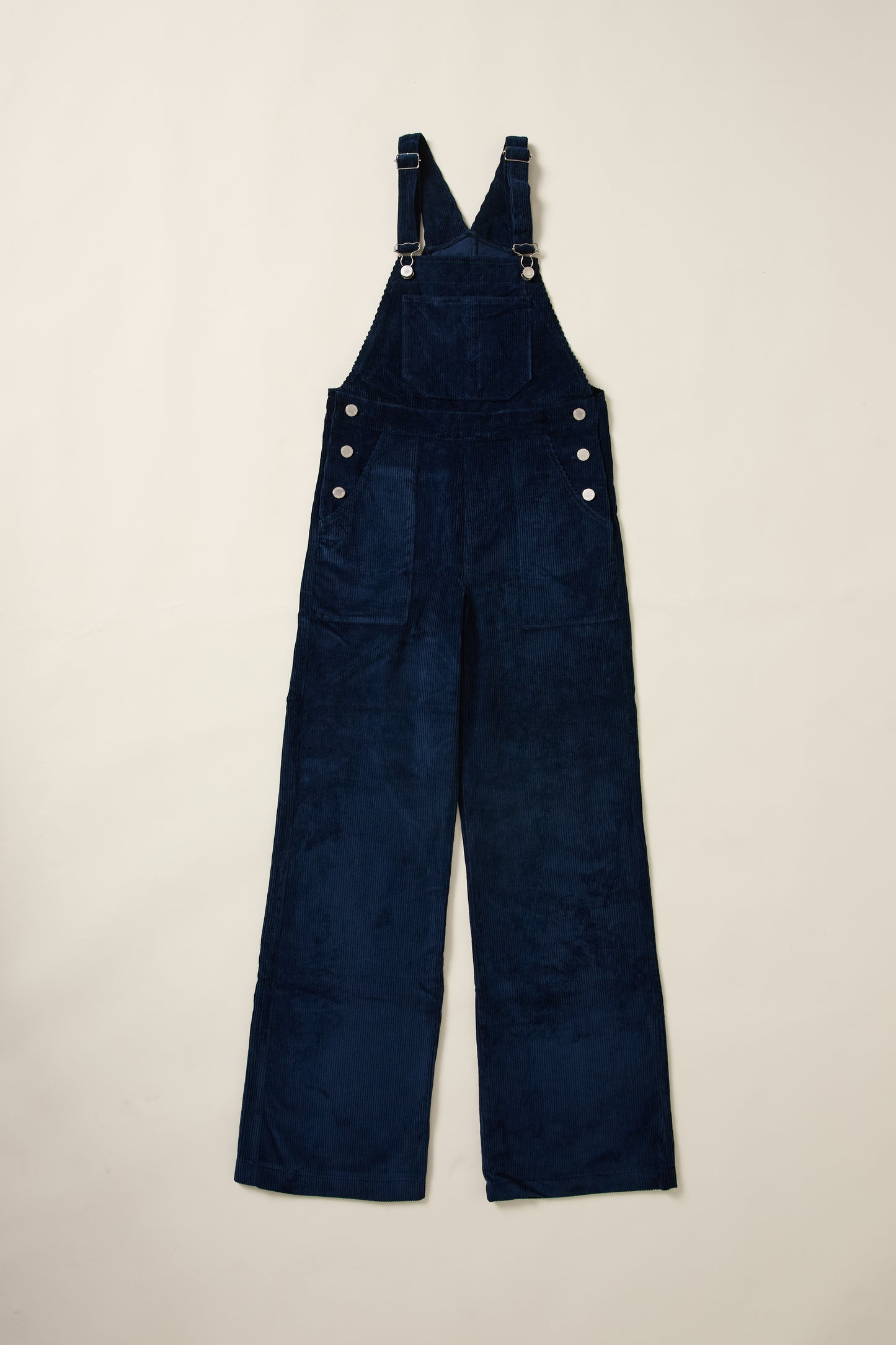 Une salopette en velour bleu en aplat.