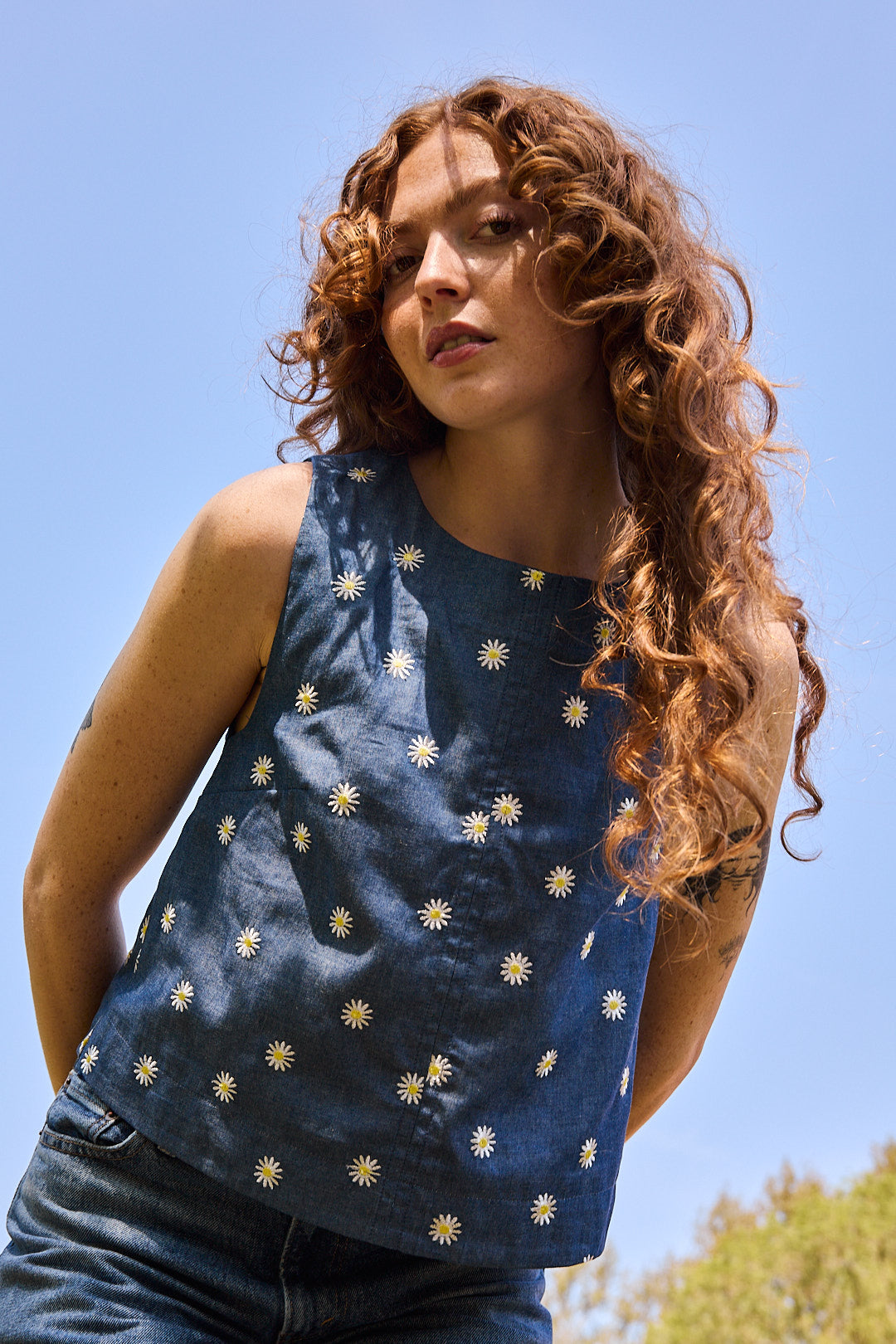 Mannequin portant le top brodé Recyclette avec un jean bleu assorti, créant un look estival.