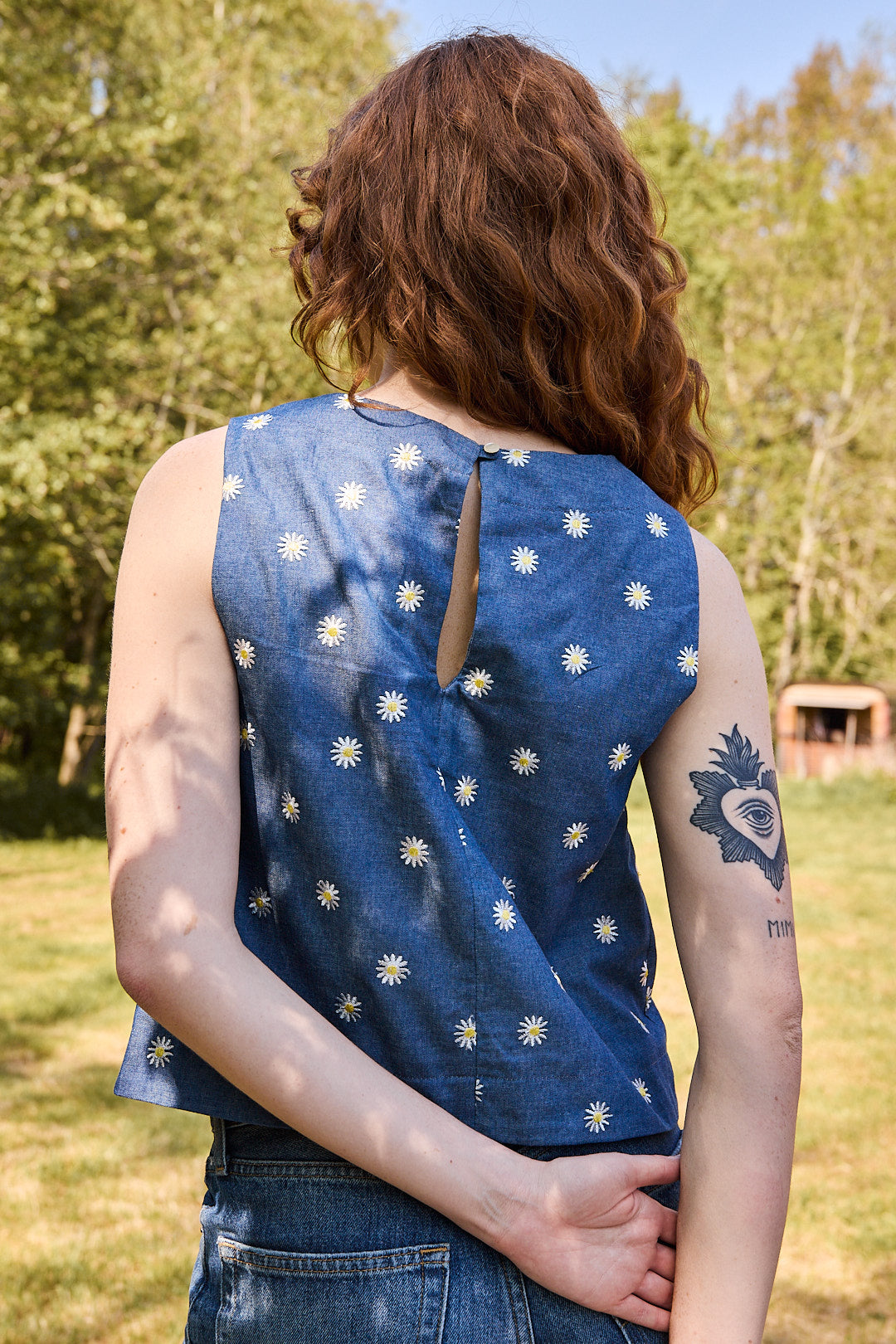 Mannequin portant le top brodé Recyclette avec un jean bleu assorti, créant un look estival.