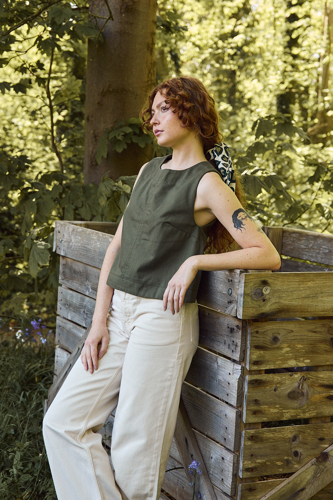 Mannequin portant le top kaki avec un pantalon écru, style sobre Recyclette. Un top chasuble, qui suit les tendances 2025.