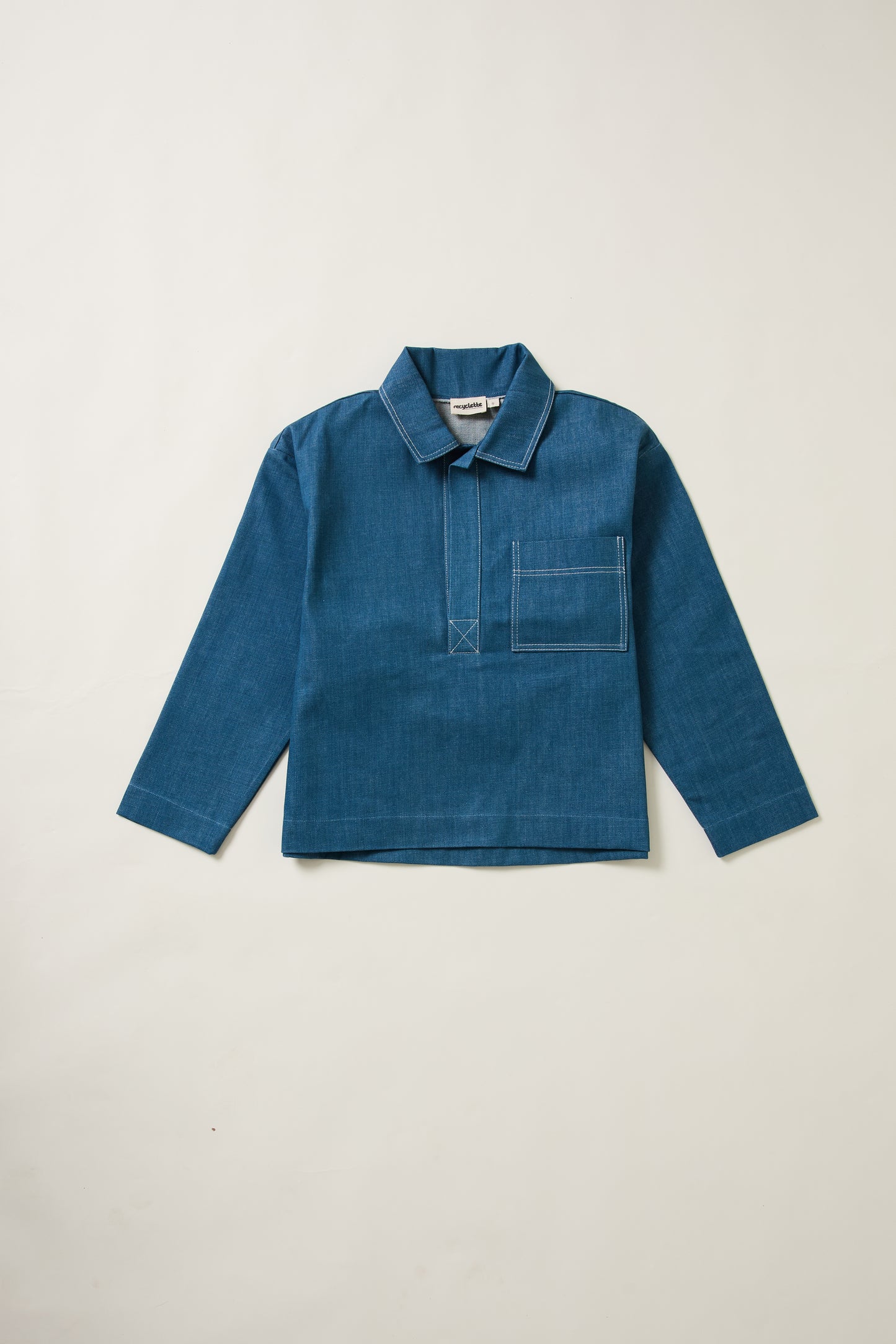Un aplat de la vareuse denim bleue Recyclette, avec sa poche sur la poitrine.