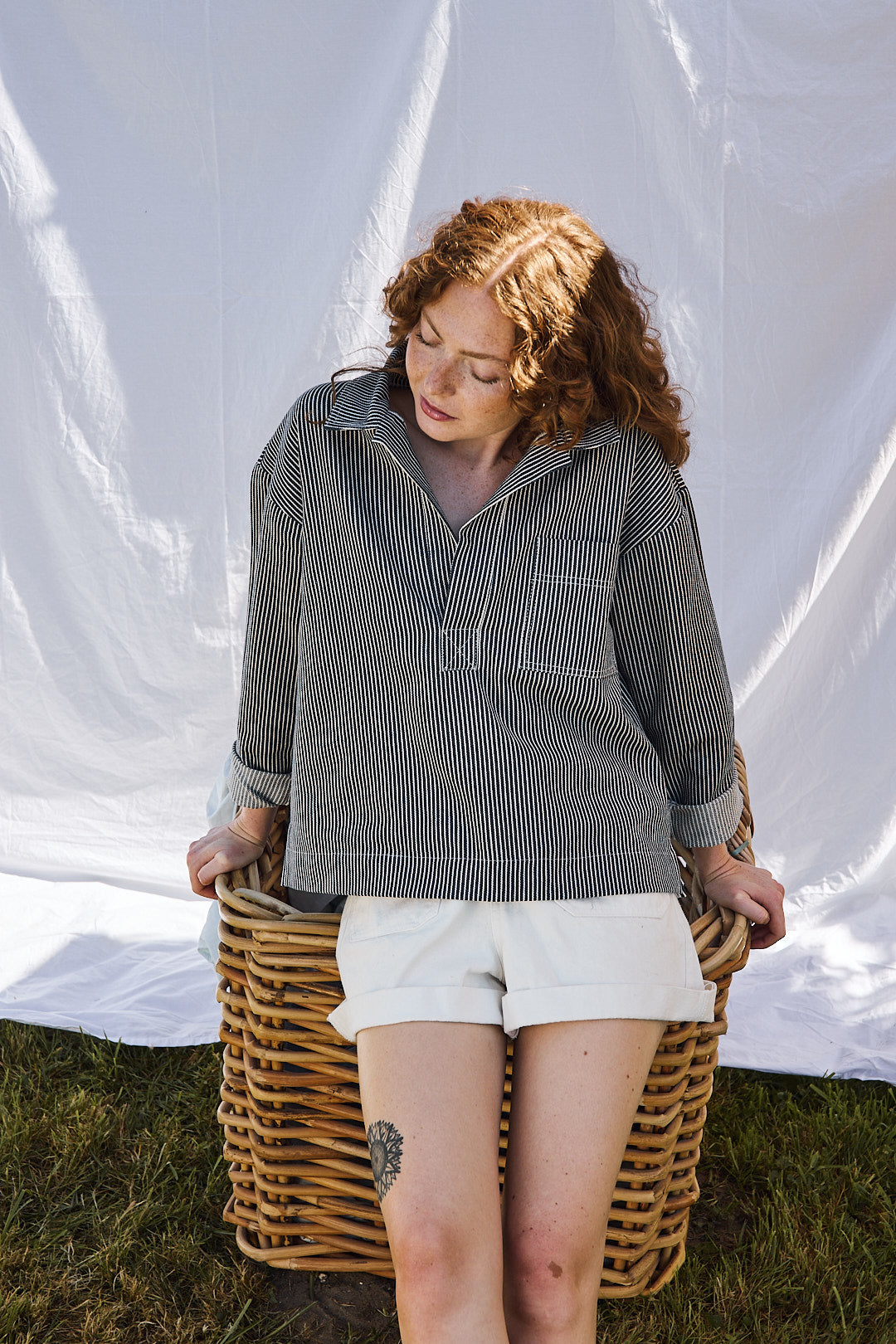 Mannequin portant la vareuse rayée bleu à col fendu, associée à un short blanc – look estival et décontracté Recyclette. Pièce fabriquée en France à partir de stocks dormants.