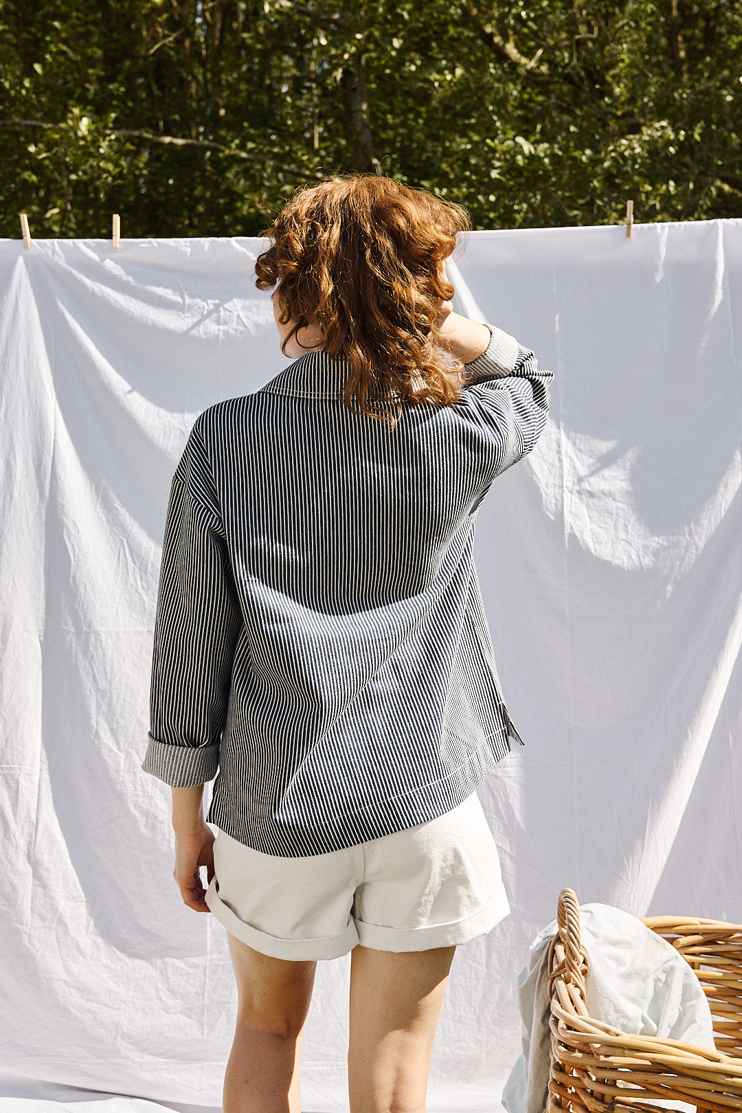 Mannequin portant la vareuse rayée bleu à col fendu, associée à un short blanc – look estival et décontracté Recyclette. Pièce fabriquée en France à partir de stocks dormants.