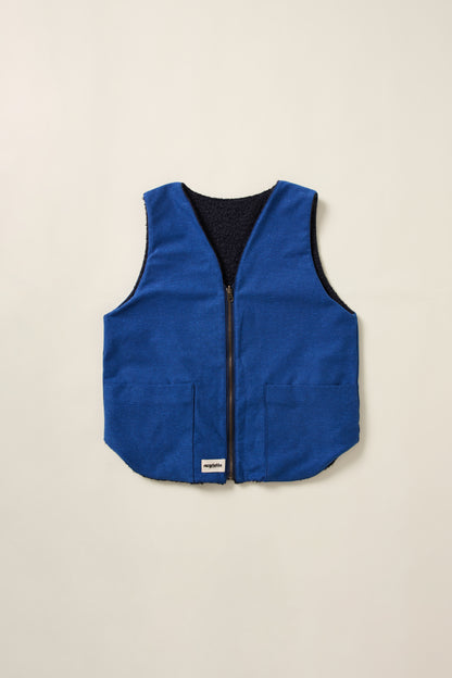 Gilet réversible, bleu denim d'un coté et et moumoute bleu de l'autre. Gilet en aplat. 