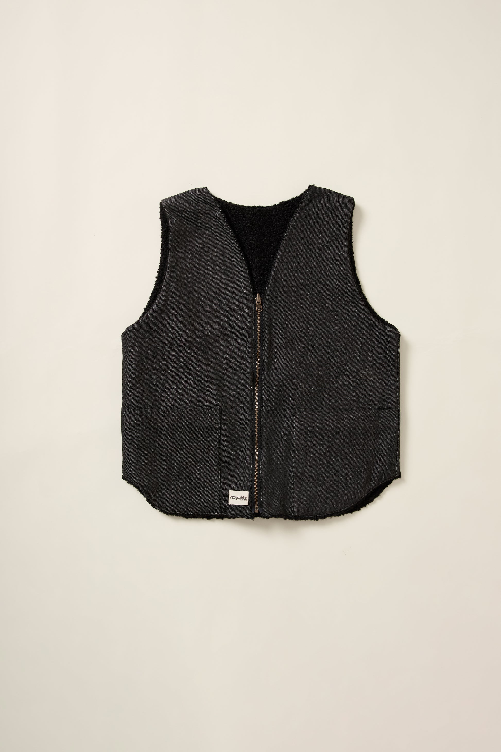 Gilet réversible, coté denim noir, sans manche, en aplat.