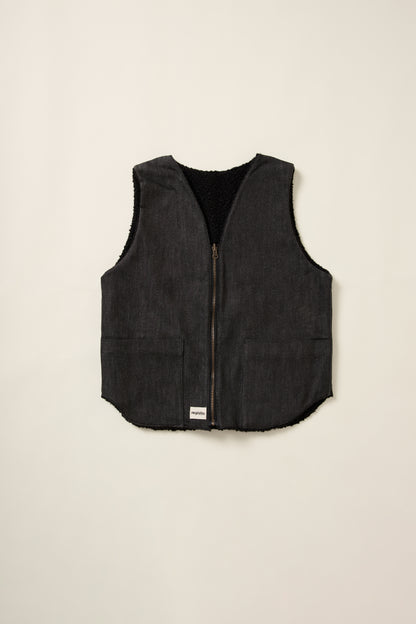 Gilet réversible, coté denim noir, sans manche, en aplat.