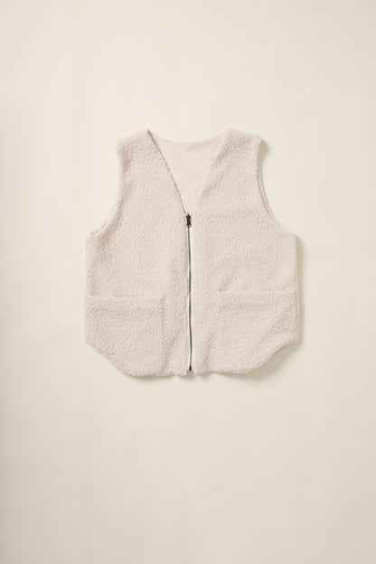 Gilet réversible sans manche du coté moumoute crème en aplat.