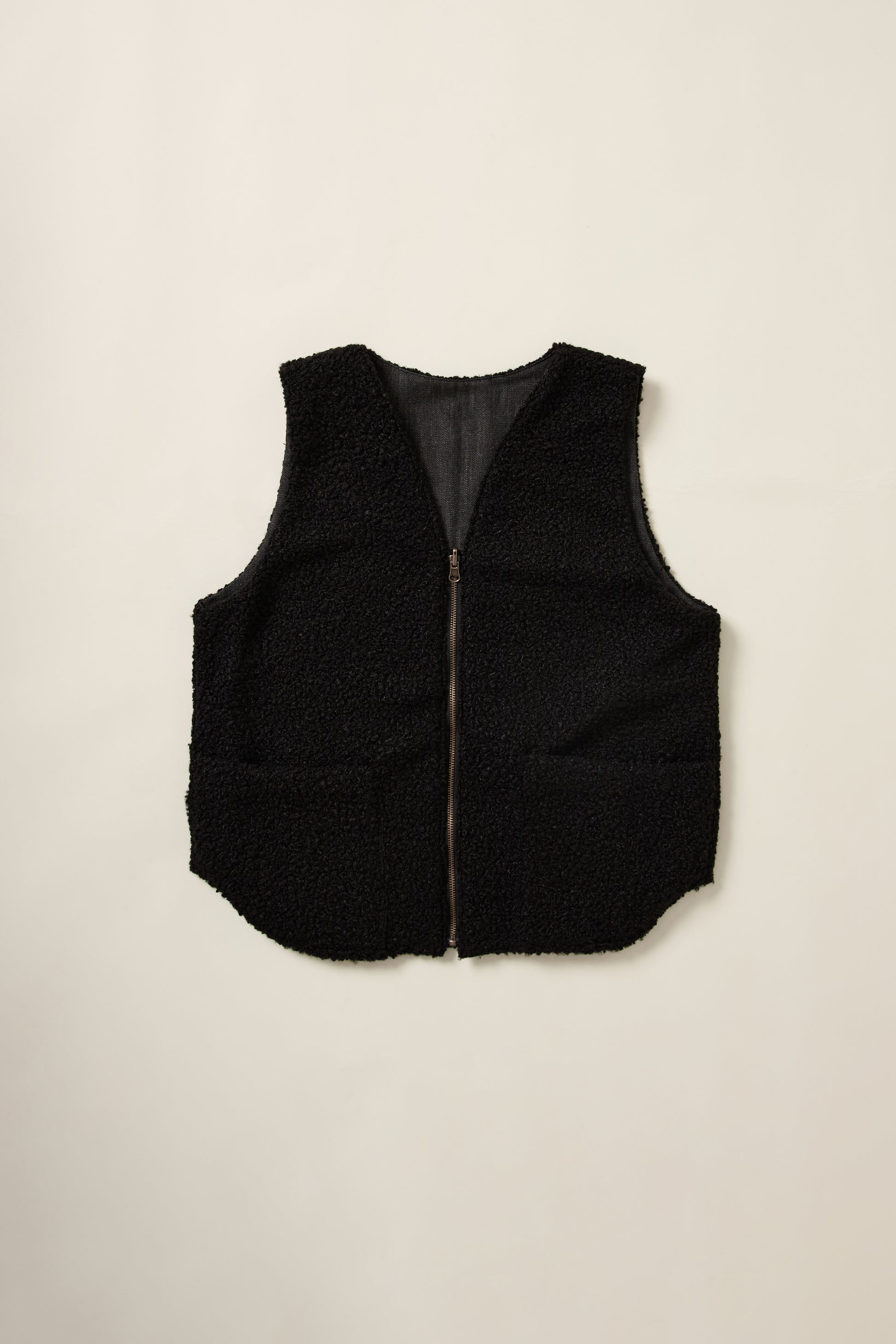Gilet réversible, sans manche, coté moumoute noir, en aplat.